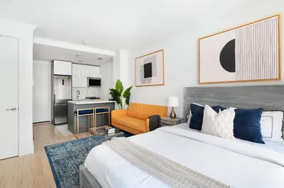 a bedroom with a bed and a living room at 1597-7 Luxury Upper East Studio W&D in unit in New York