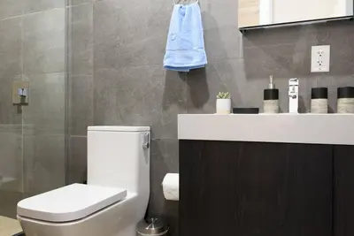 a bathroom with a white toilet and a sink at 1597-8 Luxury STUDIO Upper East Side W&D in New York