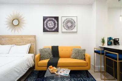 a bedroom with a bed and a yellow couch at 1597-8 Luxury STUDIO Upper East Side W&D in New York