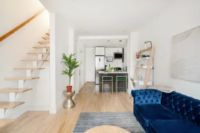 a living room with a blue couch and a kitchen at 1597-PHN PH Duplex -Private Outdoor Deck W D in New York