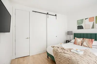 a bedroom with a bed with a green headboard at 1597-PHN PH Duplex -Private Outdoor Deck W D in New York