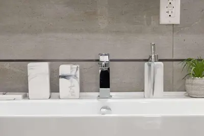 a bathroom counter with bottles and towels on it at 78-1A NEW Modern 1BR W&D Walk to Central Park in New York