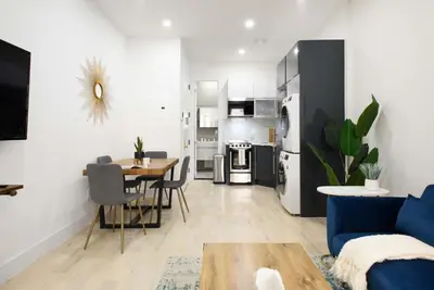 a living room with a blue couch and a table at 78-1A NEW Modern 1BR W&D Walk to Central Park in New York