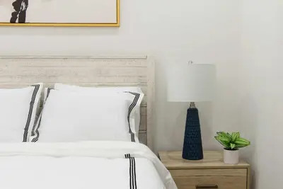 a bed with white sheets and a lamp on a night stand at 78-1A NEW Modern 1BR W&D Walk to Central Park in New York