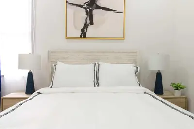 a bedroom with a white bed with two lamps at 78-1A NEW Modern 1BR W&D Walk to Central Park in New York