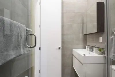 a white bathroom with a sink and a mirror at 78-1A NEW Modern 1BR W&D Walk to Central Park in New York