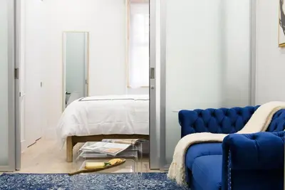 a bedroom with a blue couch and a bed at 78-1B New 1BR prime UES WD in unit BEST VALUE in New York