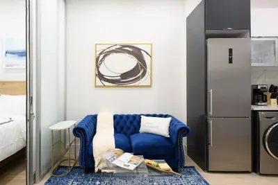 a living room with a blue couch and a refrigerator at 78-1B New 1BR prime UES WD in unit BEST VALUE in New York