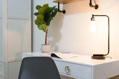 a desk with a lamp and a potted plant at 1567-1A New 2br PRIME upper East APT W&D in New York