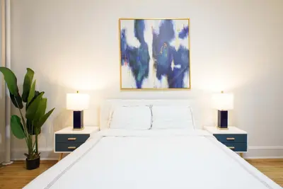 a bedroom with a large white bed with two lamps at 1567-1A New 2br PRIME upper East APT W&D in New York