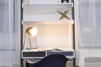 a desk with a lamp and a chair in a room at 1567-1A New 2br PRIME upper East APT W&D in New York