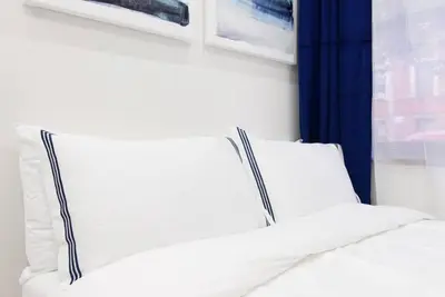 a bed with white pillows in a room with a window at 78-1D NEW Junior 1 BR Prime UES WD in unit in New York