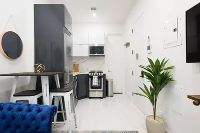 a kitchen with a table and a blue couch in a room at 78-1D NEW Junior 1 BR Prime UES WD in unit in New York