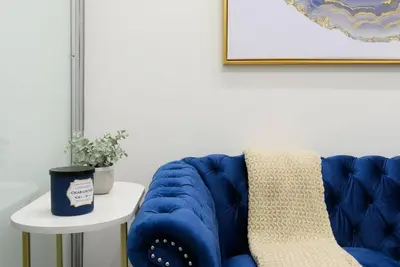 a blue couch sitting next to a table with a plant at 78-1D NEW Junior 1 BR Prime UES WD in unit in New York