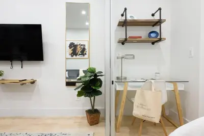 a living room with a glass table and a tv at 78-2D New furnished 1BR WD walk to Central Park in New York
