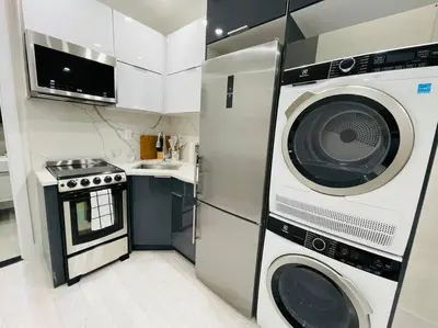a kitchen with a microwave and a washer and dryer at 78-3A Luxury BRAND NEW Modern 1BR W&D in New York