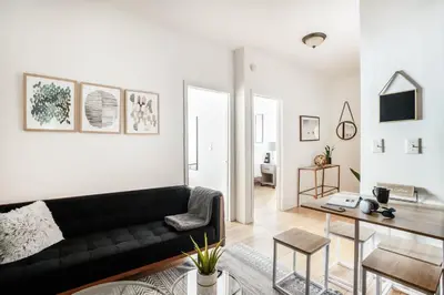 a living room with a black couch and a table at 102-1A Best Value 2BR Apt Near Central Park in New York
