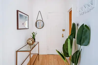 a hallway with a glass table and a plant at 102-1A Best Value 2BR Apt Near Central Park in New York
