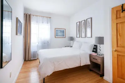 a white bedroom with a large bed and a window at 102-1A Best Value 2BR Apt Near Central Park in New York