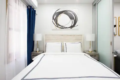 a bedroom with a large white bed and a mirror at 78-3B New Junior 1 BR Prime UES WD in unit in New York