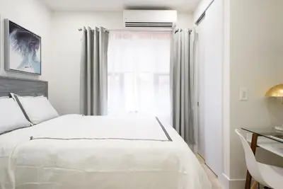 a white bedroom with a bed and a window at 78-3D Brand new 1BR prime UES WD in unit in New York