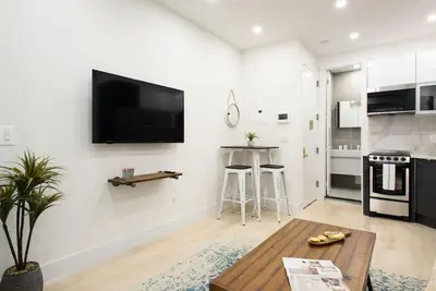 a living room with a flat screen tv on a wall at 78-3D Brand new 1BR prime UES WD in unit in New York