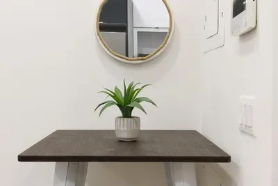 a table with a mirror and a potted plant on it at 78-3D Brand new 1BR prime UES WD in unit in New York