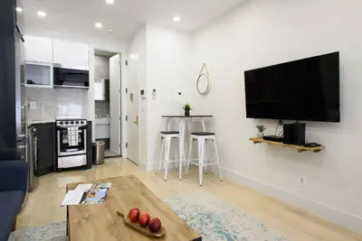 a living room with a table and a tv on a wall at 78-3D Brand new 1BR prime UES WD in unit in New York