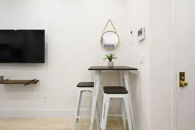 a table with two stools and a mirror on a wall at 78-3D Brand new 1BR prime UES WD in unit in New York