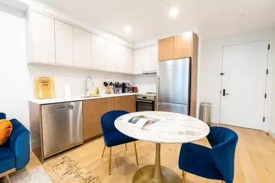 a kitchen with a table and chairs and a refrigerator at 149BK-202 NEW Condo 1BR IN PRIME GREENPOINT BK in Brooklyn