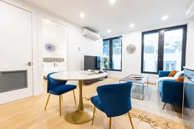 a living room with a table and blue chairs at 149BK-202 NEW Condo 1BR IN PRIME GREENPOINT BK in Brooklyn