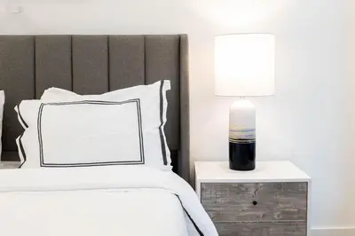 a bedroom with a bed and a lamp on a night stand at 149BK-202 NEW Condo 1BR IN PRIME GREENPOINT BK in Brooklyn