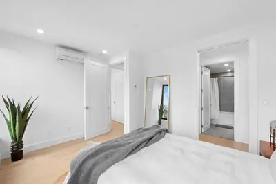 a bedroom with white walls and a bed with a blanket at 149BK-501 NEW Prime greenpoint 2BR WD in unit in Brooklyn