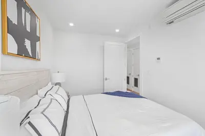 a white bedroom with a bed and a picture on the wall at 149BK-601 NEW PH 2BR-2Bath Private Rooftop W D in Brooklyn