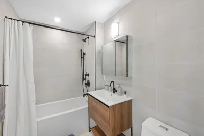 a bathroom with a sink and a toilet and a mirror at 149BK-601 NEW PH 2BR-2Bath Private Rooftop W D in Brooklyn