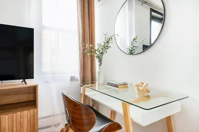 a glass desk with a mirror and a chair at 139-2E west village 1BR best value in New York