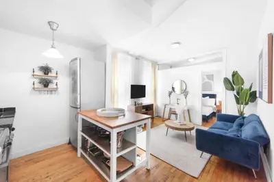 a living room with a blue couch and a table at 139-2E west village 1BR best value in New York