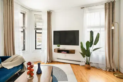a living room with a blue couch and a tv at 139-2W Prime west village Furnished 2BR Best value in New York