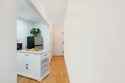 a kitchen with white cabinets and a refrigerator at 139-2W Prime west village Furnished 2BR Best value in New York