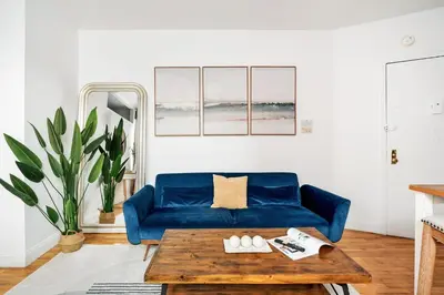 a living room with a blue couch and a wooden table at 139-3E west village 1BR best value in New York