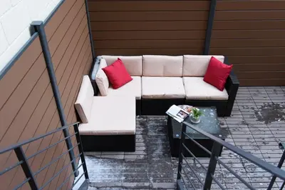 a white couch with two red pillows on a balcony at 3-2 NEW Prime E Village Private outdoor! in New York