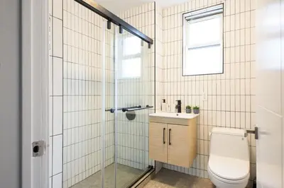 a bathroom with a toilet and a glass shower at 39-1 Renovated 3BR Prime Midtown West in New York
