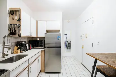 a kitchen with white cabinets and a stainless steel refrigerator at 428-2E Newly furnished 2BR Prime Midtown sleeps 5 in New York