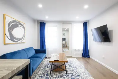 a living room with a blue couch and a tv at 350-2A Prime gramercy Newly renovated 1BR sleeps 4 in New York
