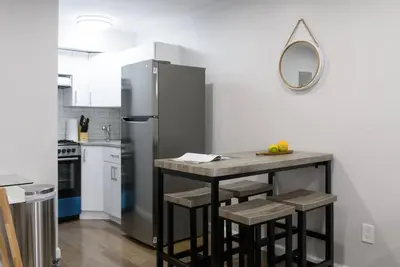 a kitchen with a refrigerator and a table with stools at 350-2A Prime gramercy Newly renovated 1BR sleeps 4 in New York