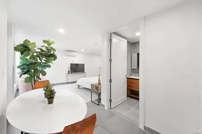a white table and chairs in a room with a bedroom at 149BK-101 New construction 2BR Private garden W-D in Brooklyn