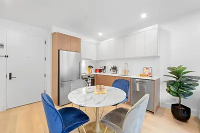 a kitchen with a table and blue chairs in a kitchen at 149BK-101 New construction 2BR Private garden W-D in Brooklyn