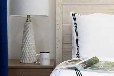 a bed with a lamp and a cup on a night stand at 78-4D Quality 1br W&D SKYLIGHT By Central Park in New York
