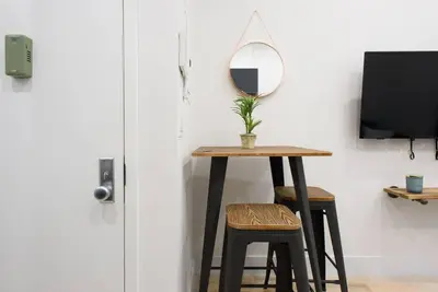 a table with two stools and a mirror on a wall at 78-4D Quality 1br W&D SKYLIGHT By Central Park in New York