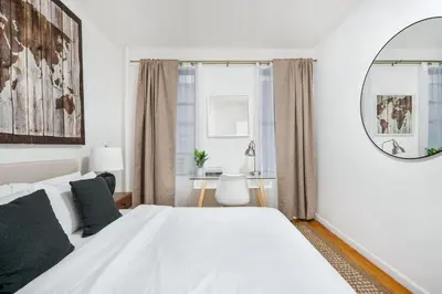 a white bedroom with a large bed and a mirror at 109-1 Huge 3BR Best Value Amazing NYC Apt in New York